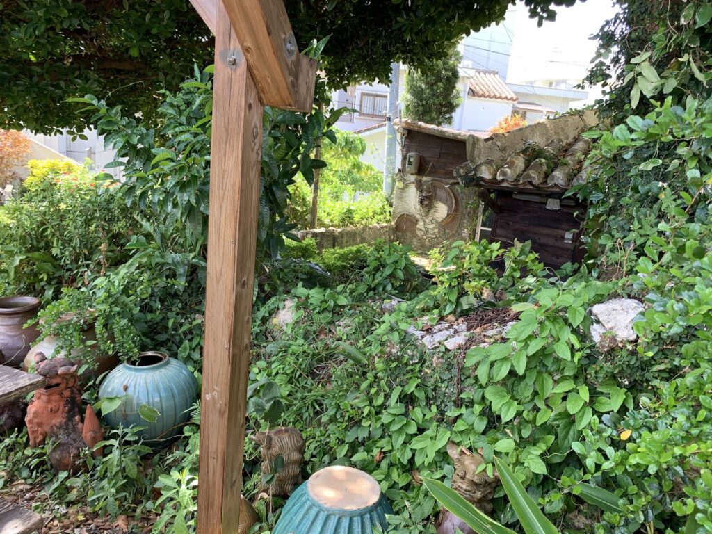 A green garden with ceramic pots and vases among the plants at a pottery shop in Naha