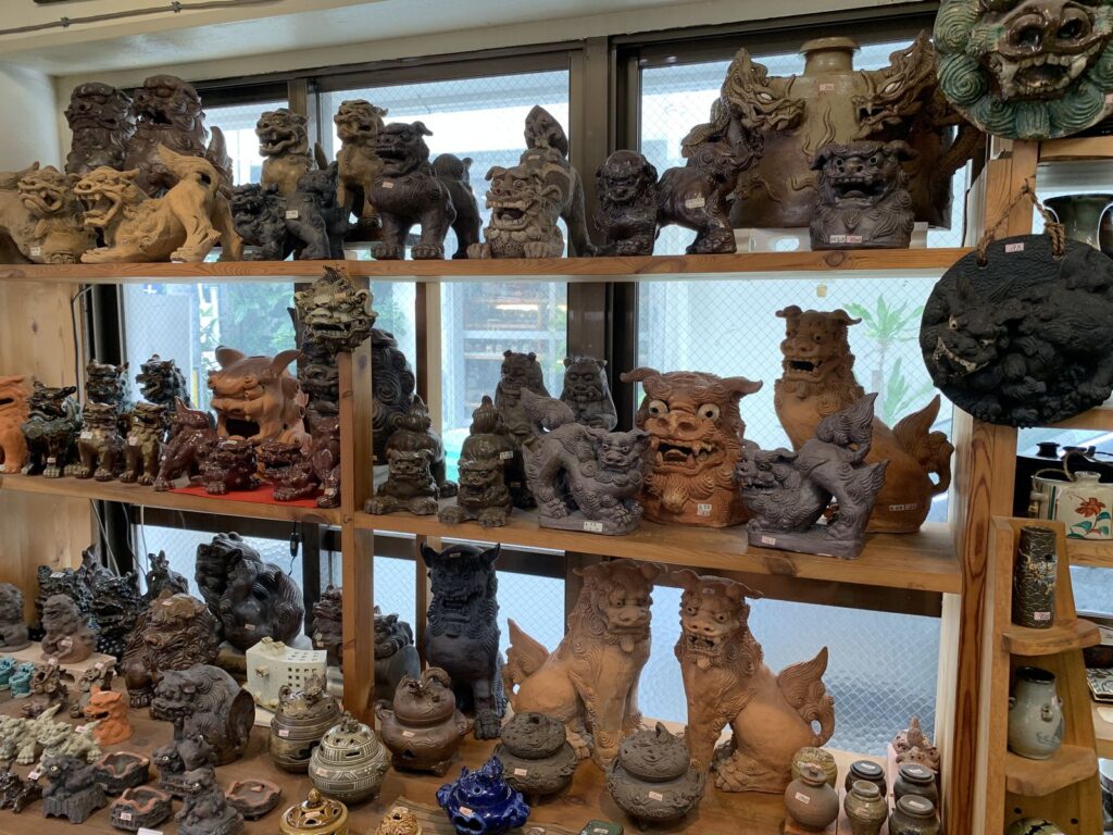 Shelves packed with ceramic shisa lion-dogs and pots in a pottery shop in Naha
