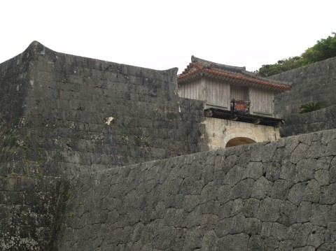 High curved limestone walls with a small wooden gate tower above, Shuri Castle